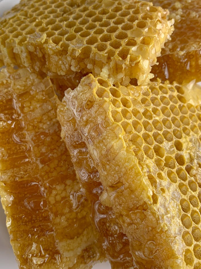 our-mission Detailed macro shot of fresh honeycomb dripping with golden honey, showcasing natural sweetness.